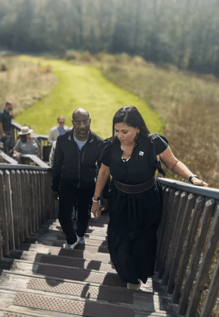 Sen. Warnock (left) and Muscogee (Creek) citizen and Director of Advocacy for ONPPI Tracie Revis (right) climb the Great Temple Mound in November 2023. Photo by MM Staff.